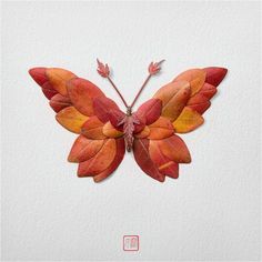 an orange and red butterfly made out of leaves