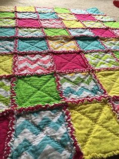 a colorful quilt is laying on the floor