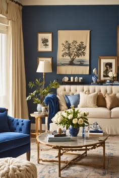 a living room with blue walls and white couches, coffee table and paintings on the wall