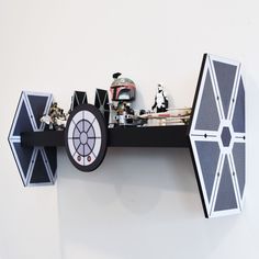 a star wars themed clock is hanging on the wall next to other toys and figurines