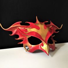 DESCRIPTIONRise from the ashes and transform anew wearing this gorgeous red & gold leather Phoenix Mask. This firebird piece is perfect for Carnivale or Bird CosPlay! Quality leather bird mask, fantastic for Carnivale or Mardi Gras costume. Any color. Waterproofed leather, glossy or matte finish, & several choices to affix the mask (cord, elastic, ribbon, waterproof cord). Measurements: 10" high x 14" wide (tallest & widest points); 10" high between the eyes; 3" wide x 1.5" tall eye Phoenix Mask, Bird Cosplay, Animal Masquerade Mask, Phoenix Costume, Bird Mask, Bird Costume, Bird Masks, Mardi Gras Costumes, Rise From The Ashes