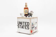 a bottle of whiskey sitting on top of a wooden box with the word united states printed on it