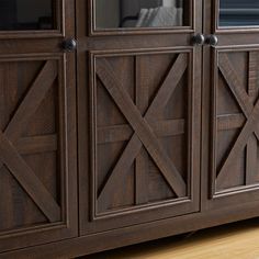 a large wooden cabinet with glass doors on the front and side panels, in a living room