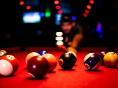 billiards are lined up on the table in a dark room with neon lights