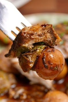 a piece of meat and vegetables being held by a fork