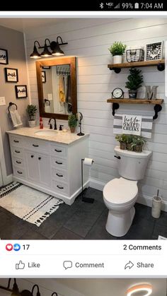 a white bathroom with black and white accessories on the shelves above the toilet is decorated with potted plants