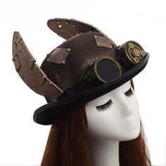 Discover the magnificent Steampunk Hat and Goggles. An original steampunk hat with two wings on the sides. A wonderful journey into the original world of steampunk. With leather straps to give an industrial effect and a famous pair of goggles to give the final touch to the hat. Steampunk Brimmed Costume Hat For Cosplay, Steampunk Costume Accessories With Brimmed Shape, Steampunk Brimmed Costume Accessories For Party, Steampunk Brimmed Costume Accessories For Costume Party, Punk Style Adjustable Costume Hats For Cosplay, Adjustable Punk Costume Hats And Headpieces For Cosplay, Steampunk Halloween Costume Accessories, Adjustable Brimmed Costume Accessories For Cosplay, Steampunk High Crown Costume Accessories For Cosplay