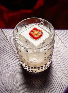 a glass filled with ice and water on top of a table