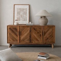 a living room with a large wooden cabinet next to a lamp