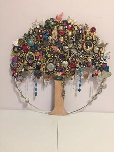 a tree made out of many different types of buttons and beads on a wooden stand