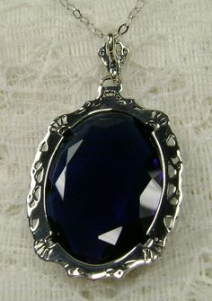 "Pendant Description Custom Inspired by Victorian era designs, I now offer this lovely Antique reproduction in sterling silver. The flawless simulated 22ct faceted blue sapphire is 24mm long (15/16th\") and 18mm in width (3/4th\"). The entire pendant is 1.5\" long and 7/8\" wide. The chain (if chosen) is between 16-18\" in length and is marked 925 as well. Notice the beautiful craftsmanship of the Victorian filigree setting. This pendant necklace is a true reproduction of and old Victorian cameo Blue Sterling Silver Costume Jewelry, Formal Nickel-free Round Pendant Jewelry, Nickel Free Round Pendant For Formal Occasions, Blue Costume Jewelry In Sterling Silver, Nickel-free Round Pendant For Formal Wear, Nickel-free Round Pendant For Formal Occasions, Silver Sapphire Oval Pendant Jewelry, Silver Sapphire Jewelry For Jewelry Making, Hallmarked Sapphire Jewelry As Gift