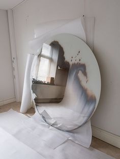 a broken mirror sitting on top of a white sheet of paper next to a window