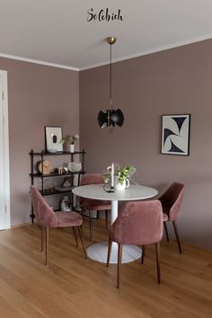 a dining room with pink chairs and a white table