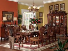 a formal dining room table with chairs and china cabinet