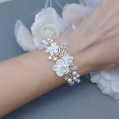 a close up of a person's arm wearing a bracelet with flowers on it