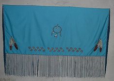 a blue wall hanging with feathers and beads on it