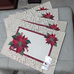 three place mats with poinsettis on them