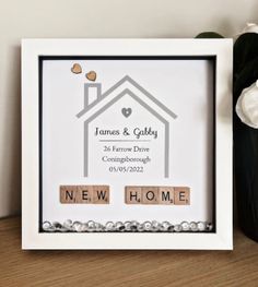 a photo frame with two scrabbles in it and the words new home