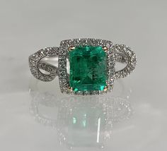 Square cut ring, emerald ring, emerald engagement ring, emerald ring for women, emerald diamond ring, 18k Emerald ring, 18K white gold ring A glowing modern emerald ring featuring a 1.27-carat emerald cut center stone accented by 0.42 carats of diamonds set in a solid 18k white gold twisted halo setting. *Ring size: US 6 3/4 *Ring weight: 4.30 Grams *Center stone dimensions: 7.5X6mm Green Diamond Platinum Ring Fine Jewelry, Fine Jewelry Green Diamond Ring In Platinum, Fine Jewelry Green Diamond Platinum Ring, Green Platinum Diamond Ring, Green Diamond Cut Diamond Ring, Green Emerald Ring With Diamond Accents In Platinum, Platinum Emerald Ring With Diamond Accents, Emerald Ring With Halo Setting In Platinum, Green Emerald Ring With Halo Setting In Platinum