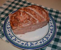 a piece of meat sitting on top of a blue and white plate next to a green checkered table cloth