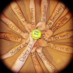 a group of hands holding a tennis ball with words written on it