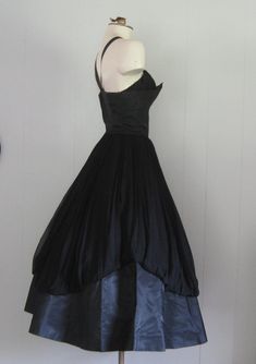 APPROXIMATE MEASUREMENTS (INCHES): Current Size: XS/S Tag size: 10 (please note this is vintage sizing; see measurements for more accurate current size/fit) Bust: 34 Waist: 25 Hip: OPEN Bodice (shoulder to waist): 17 Skirt (waist to hem): 32 CONDITION Excellent DESCRIPTION 1950s party dress Black taffeta and black chiffon fabric Fitted bodice and full skirt Back metal zip closure No manufacturer's label Party Evening Dress With Pleated Bodice, Tea Length, Pleated Bodice Tea Length Evening Dress For Party, Pleated Bodice Tea-length Evening Dress For Party, Tea Length Evening Dress With Pleated Bodice, Tea-length Evening Dress With Pleated Bodice, Tea Length Pleated Bodice Evening Dress, Tea-length Pleated Bodice Evening Dress, 1950s Sleeveless Vintage Party Dress, 1950s Style Sleeveless Vintage Party Dress