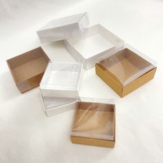 four open boxes sitting on top of a white tablecloth covered floor with no one around them