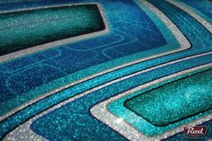 a close up view of the blue and silver paint on a car's hood