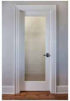 an empty room with a glass door and wood flooring in front of the doorway