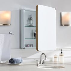 a bathroom with a sink, mirror and towels on the counter top in front of it