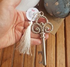 a person is holding a key with a tassel on it's end and the keys are in front of them