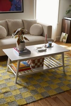 a white coffee table sitting on top of a yellow rug in front of a couch