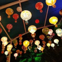 many colorful lanterns are hanging from the ceiling