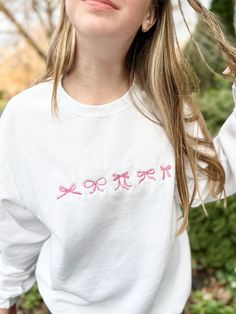 Channel your inner darling with this adorable coquette-inspired sweatshirt, featuring a delicate embroidered bows on the center chest. This soft and cozy crewneck is perfect for layering or wearing on its own, adding a touch of sweetness and femininity to any outfit. Available in a variety of colors to suit your style, this sweatshirt is sure to become a staple in your wardrobe. Features: Soft and comfortable unisex fit Embroidered coquette bow detail Choose your thread color This sweatshirt is perfect for: Casual everyday wear Adding a touch of whimsy to your outfit Gifting to a friend or loved one Shop now and embrace your inner coquette! Embroidered Bows, Bow Sweatshirt, Ballet Aesthetic, Oversized Crewneck, Coquette Bow, Cute Shirt, Soft Girl, Casual Everyday, Bow Detail