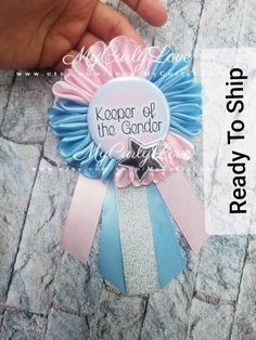 a person holding a badge with the words keeper of the gender on it and a ribbon around it