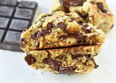 two chocolate chip cookies stacked on top of each other next to a bar of chocolate