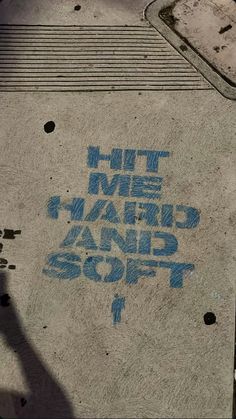 graffiti on the sidewalk that says hit me with hand and foot