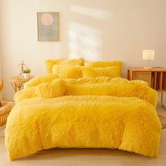 a bed with yellow comforters and pillows in a room