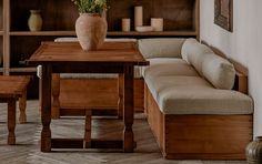 a wooden table sitting next to a couch in a living room under a book shelf