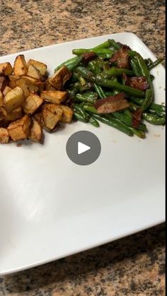 a white plate topped with green beans and potatoes