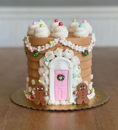 a gingerbread house cake with frosting and decorations