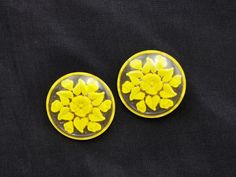 Vintage 1950s Lucite Clip-On Earrings with Yellow Floral Reverse Carving, Authentic 1950s vintage earrings. Enhance your vintage jewelry collection with these stunning 1950s lucite clip-on earrings. Crafted in circular shapes, these unique earrings feature a beautifully reverse-carved floral design on the back, hand-painted in a vibrant lemon yellow. This special technique creates a captivating 3D effect when viewed from the front, making these earrings a true work of art. Dimensions: Diameter: Vintage Handmade Earrings For Anniversary, Vintage Round Screw Back Earrings, Vintage Round Earrings With Screw Back, Mid-century Clip-on Earrings, Vintage Screw Back Earrings For Vintage Events, Vintage Plug Earrings For Anniversary, Retro Round Earrings For Anniversary, Vintage Handmade Clip-on Earrings For Wedding, Vintage Handmade Yellow Earrings