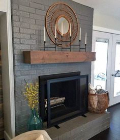 the fireplace is painted gray and has candles on it, along with a basket full of flowers