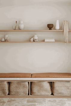 a shelf with some baskets and vases on it