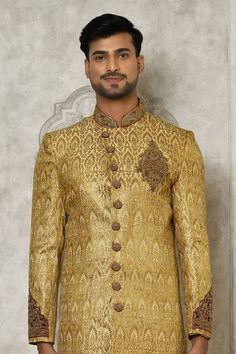 Gold jamewar sherwani with hand embroidery.
Components: 1
Pattern: Hand embroidered
Neckline: Mandarin collar
Sleeve Type: Full
Fabric: Jamewar
Color: Gold
Other Details: 
Overlapping placket on sherwani
Closure : Sherwani - Front buttons
Note : Churidar worn by the model is not sale.
Occasion: Mehendi and Puja,Sangeet - Aza Fashions Semi-stitched Gold Kurta With Naqshi, Ceremonial Raw Silk Sherwani With Naqshi, Ceremonial Naqshi Sherwani In Raw Silk, Gold Sherwani With Resham Embroidery And Kundan, Traditional Gold Raw Silk Wear With Naqshi, Gold Traditional Wear With Naqshi Drape, Raw Silk Bandhgala With Resham Embroidery, Gold Jamawar Kurta With Resham Embroidery, Traditional Gold Unstitched Suit With Naqshi Detailing