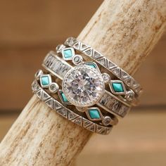 a close up of a ring on top of a tree branch with stones and diamonds