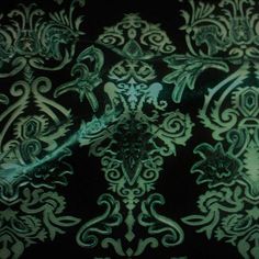 a black and green wallpaper with an intricate design on it's surface,