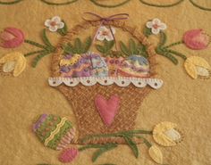 a close up of a piece of cloth with an embroidered design on it and flowers in the background