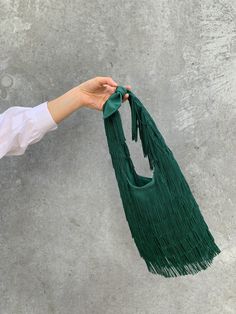 One of our most loved handbags, the Idina bag, has been re-interpreted in a smaller size and fun colors. The Grace bag, in tangerine and emerald, are made for women that want a bag that will upgrade a look and makes her feel special carrying it. We are personally in love of their movement and beauty :). Handmade in a decadent emerald fringe chainette fabric, it features a knotted handle.The Grace bag is made entirely by hand in the North of Spain. We love wearing it as a statement bag. Material: North Of Spain, Statement Bag, Black Fringe, The Grace, Feel Special, Feeling Special, A Bag, In Love, Emerald