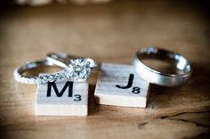 two wedding rings sitting on top of blocks with the letters j and m in them